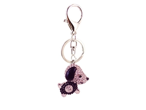 Détail du porte-clés chiot avec strass roses et noirs sur un fermoir argenté