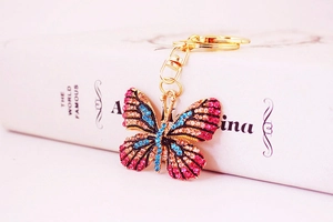 Detailed macro view of the pink and blue rhinestone crystal gradient butterfly keychain charm