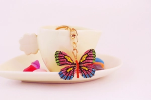 Macro shot of colorful rhinestone butterfly keychain with golden lobster clasp and charms