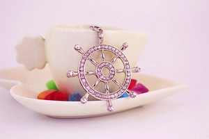 Détail macro du pendentif gouvernail argenté avec strass brillants sertis pavé
