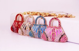 Detail of four crystal handbags keychains in red, blue, pink and white with gold lobster clasps