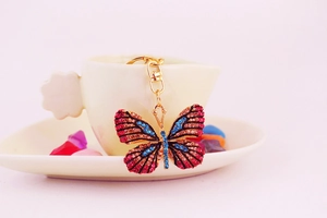 Close-up of a butterfly rhinestone keychain with colorful crystals on a gold alloy base