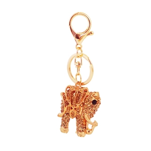 Golden elephant keychain with amber rhinestones and lobster clasp on white background