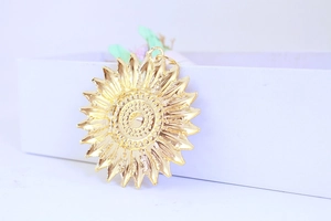 Close-up of golden sunflower pendant with detailed multi-layered petals and center texture