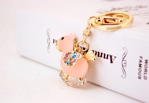 Macro view of pink crystal rocking horse keychain with colorful rhinestones on book