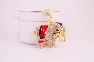 Detail of golden elephant keychain with sparkling rhinestones and red enamel coating