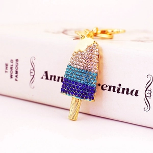 Colorful rhinestone popsicle keychain with gradient crystals and gold clasp on book