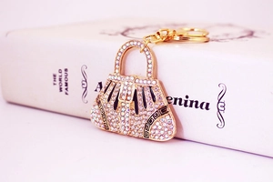 Macro shot of handbag keychain featuring rainbow rhinestones and Greek meander pattern