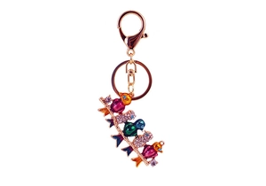 Macro detail of colorful rhinestone bird keychain with gold lobster clasp and key ring
