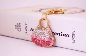 Macro shot of gold-plated handbag keychain with sparkling pink and white rhinestones
