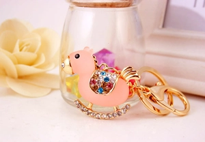 Close-up of pink enamel rocking horse keychain with sparkling colorful rhinestones