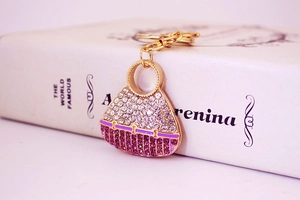Detail of crystal handbag keychain with purple rhinestones on a book background