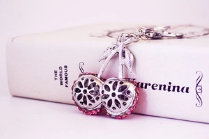 Detailed view of rhinestone-studded cherry keychain with intricate cutout leaf design