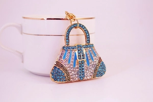 Detailed macro view of rhinestone-encrusted handbag keychain with blue crystals