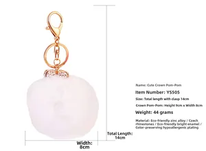 Dettaglio del portachiavi a pompon in finta pelliccia bianca con corona di strass dorati