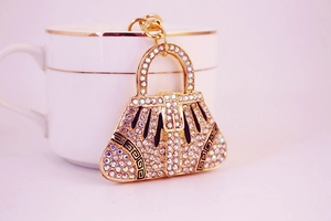 Detailed close-up of a golden handbag keychain with sparkling white rhinestones