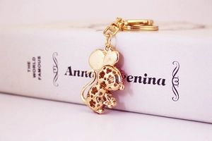 Detailed macro view of golden mouse pendant with pink crystal and hollow pattern