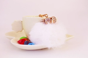 Dettaglio portachiavi a pompon bianco con corona dorata e strass scintillanti