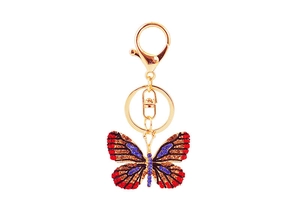 Close-up of golden butterfly keychain with colorful inlaid crystals and lobster clasp