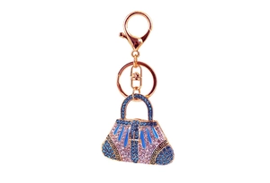 Detail of blue rhinestone handbag keychain with rose gold alloy and enamel patterns