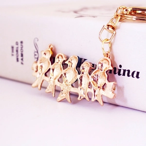 Charming gold metal keychain featuring five birds perched on a branch for bags and keys