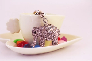 Gros plan d'un porte-clés éléphant avec strass étincelants suspendu à une tasse à café