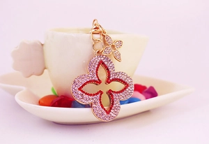 Nahaufnahme von rosa Strass Kleeblatt Schlüsselanhänger mit goldener Legierung