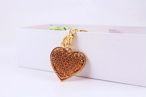 Détail du pendentif en forme de cœur doré avec motifs de petits cœurs évidés gravés