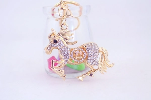 Détail d'un porte-clés cheval doré serti de cristaux brillants avec un fermoir mousqueton