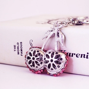 Creative silver cherry keychain with pink rhinestones and hollow floral metal design