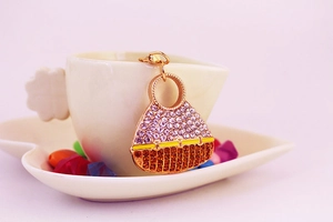 Detail of crystal encrusted handbag keychain with purple and amber rhinestones