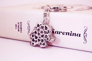 Detail of silver elephant keychain featuring hollow heart and star patterns on back