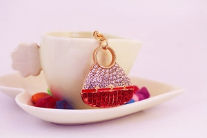 Detailed macro view of crystal handbag pendant featuring red and white rhinestones