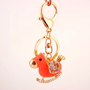 Vibrant orange rocking horse keychain with crystal accents and gold-plated hardware