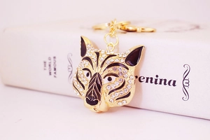 Close-up of gold tiger head keychain with white rhinestones and black enamel detail