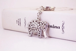 Détail du porte-clés éléphant argenté avec motifs de cœur ajourés sur un livre