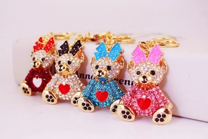 Detailed view of four rhinestone teddy bear keychains in red, black, blue, and pink colors
