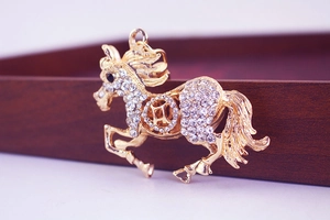 Dettaglio macro del portachiavi cavallo dorato con cristalli scintillanti e design a moneta