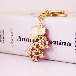 Golden crystal mouse keychain with hollow floral pattern and red rhinestones