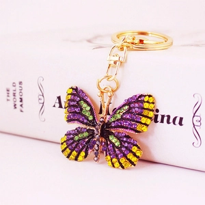 Sparkling rhinestone butterfly keychain in gold finish with vibrant purple and green crystals