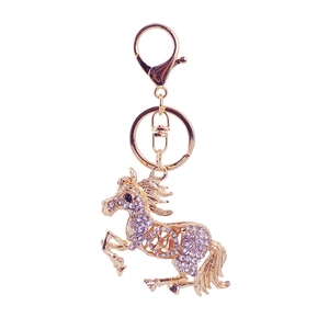 Porte-clés cheval au galop avec cristaux étincelants et finition dorée sur fond blanc