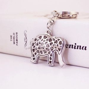 Porte-clés éléphant en métal argenté avec motifs de cœur sur un livre blanc