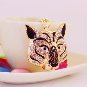 Sparkling rhinestone tiger head keychain in gold alloy finish hanging on a cup