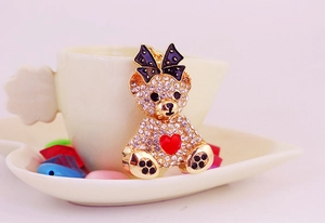 Detail of bear keychain featuring sparkling rhinestones and a red heart on golden metal