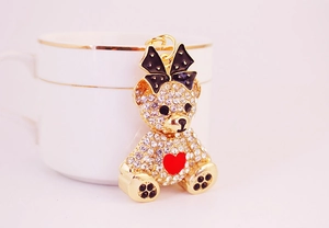 Close-up of sparkling rhinestone bear keychain with red heart and polka dot bow detail
