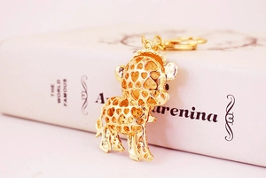 Nahaufnahme eines goldenen Giraffen-Schlüsselanhängers mit Herzmuster auf Buch