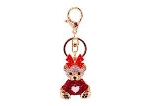 Detailed close-up of a luxury sparkling rhinestone teddy bear keychain with a red bow