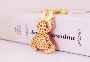 Detailed macro view of the gold bear keychain with hollow hearts and pink rhinestone accents