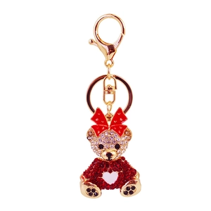 Sparkling rhinestone bear keychain with red bow and heart detail on gold metal base