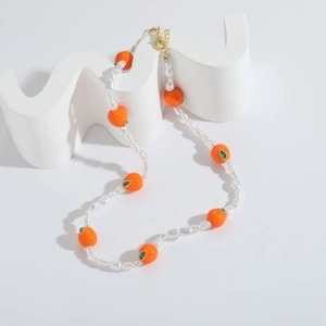 Elegante parelketting met oranje dadelpruim hanger en groene emaille bladeren